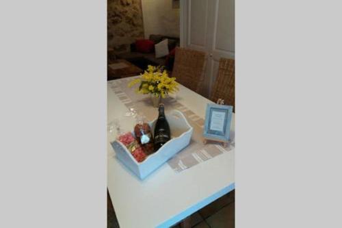 a table with a bottle of wine and flowers on it at Bastide Provençale Les Mûriers d'Engaspaty in Seillans