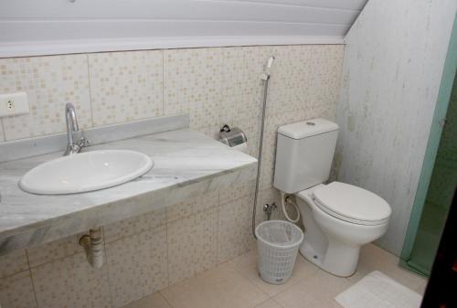 uma casa de banho com um WC e um lavatório em Pousada do Lago Ltda em Conceição do Mato Dentro