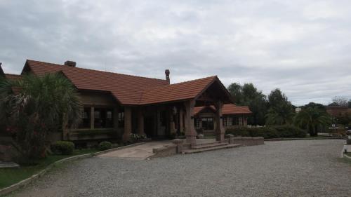 a house with a red roof on a gravel driveway at Villa de Merlo All Inclusive & Spa by MH in Merlo