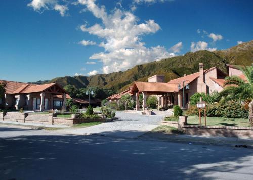 a street in a town with houses and mountains at Villa de Merlo All Inclusive & Spa by MH in Merlo