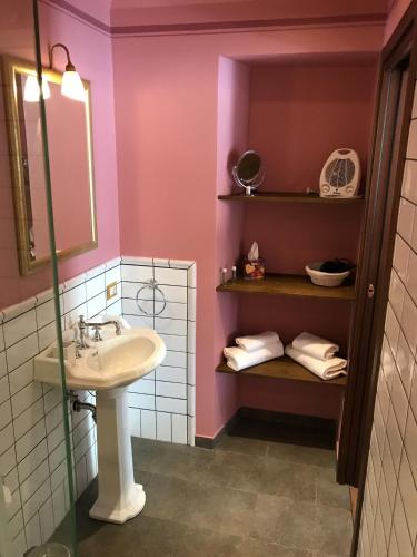 a bathroom with a sink and a shelf with towels at B&B Lago Maggiore in Cannobio