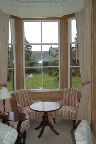 a living room with two chairs and a table and a window at Lubnaig Guest House in Callander