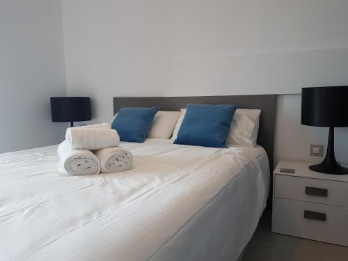 プレヤス・デ・オリフエラにあるLuxury ground floor apartment Terrazzas de Campoamor PG009の大きな白いベッド(枕2つ、ランプ2つ付)