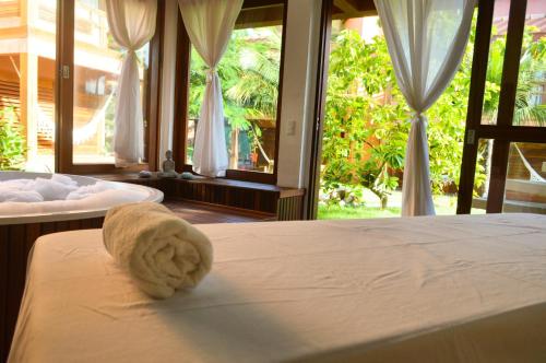 a bed with a white towel on it in a bedroom at Naquela Jericoacoara in Jericoacoara