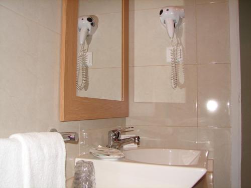 a white sink sitting under a mirror in a bathroom at Hotel Santa Barbara in Beja