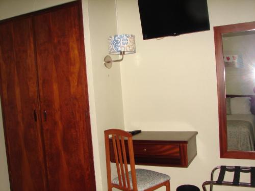 a room with a desk and a chair and a mirror at Hotel Santa Barbara in Beja