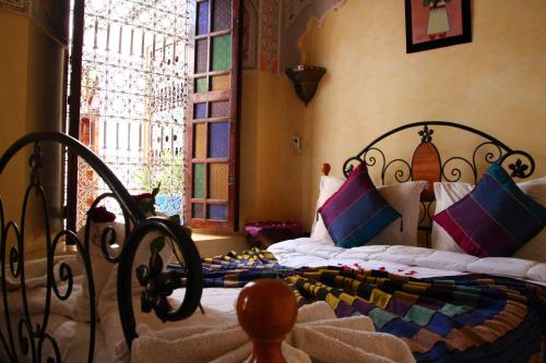 a bedroom with a bed and a window at Riad Bibtia in Marrakech