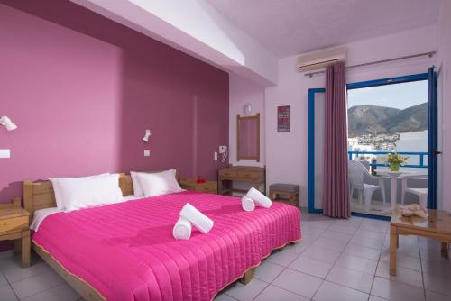 a purple bedroom with a large bed with pink sheets at Erofili Apartments in Hersonissos