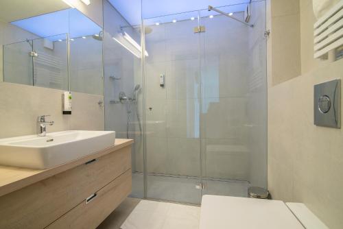ブワディスワボボにあるApartament 65 Przy plazyのバスルーム(洗面台、ガラス張りのシャワー付)