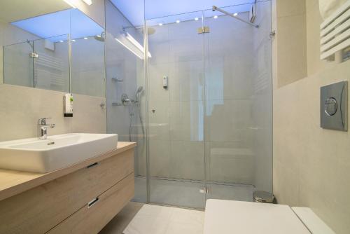 a bathroom with a sink and a glass shower at Apartament 65 Przy plazy in Władysławowo