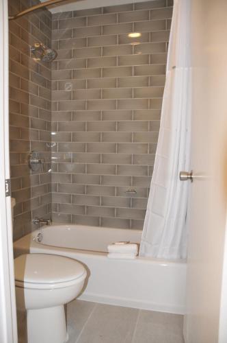 a bathroom with a tub and a toilet and a shower at Howard Johnson by Wyndham Florence in Florence