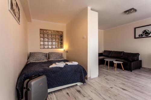 niewielka sypialnia z łóżkiem i kanapą w obiekcie Zabrze Centrum Apartament w Zabrzu