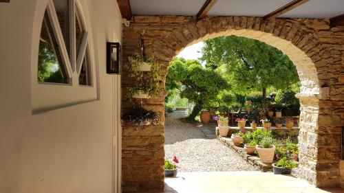an archway with potted plants in a garden at Chambres d'Hôtes Secret Pyrenées in Lasseube