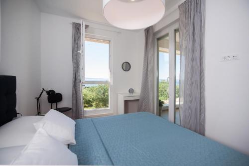 a bedroom with a blue bed and a window at Apartment Morska vila in Split