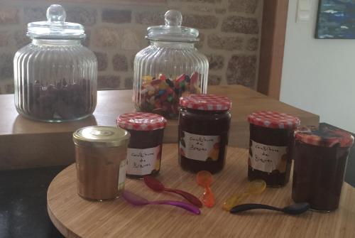 un groupe de pots de confiture sur une table en bois dans l'établissement Le bouddha du lac, à Saint-Germain-de-Tallevende