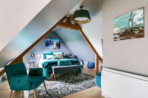 a bedroom with a blue bed and a green chair at Le bouddha du lac in Saint-Germain-de-Tallevende