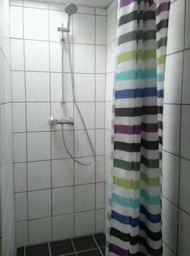 a bathroom with a shower with a shower curtain at Room In Gedser Centrum in Gedser