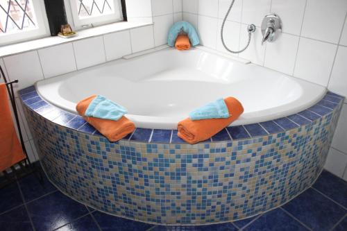 eine Badewanne im gefliesten Bad mit Handtüchern in der Unterkunft Bella Citta Vecchia in Limburg an der Lahn