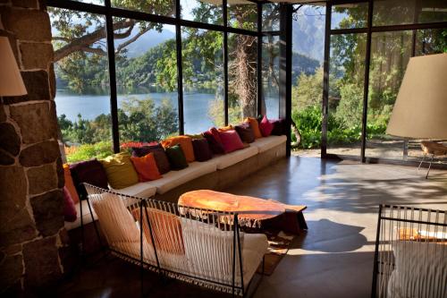 a living room with a couch with a view of a lake at Hotel Antumalal in Pucón