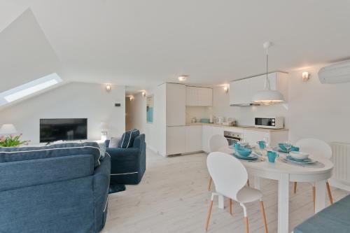 a living room with a blue couch and a table at Apartamenty Gdańsk EU - Waterlane in Gdańsk