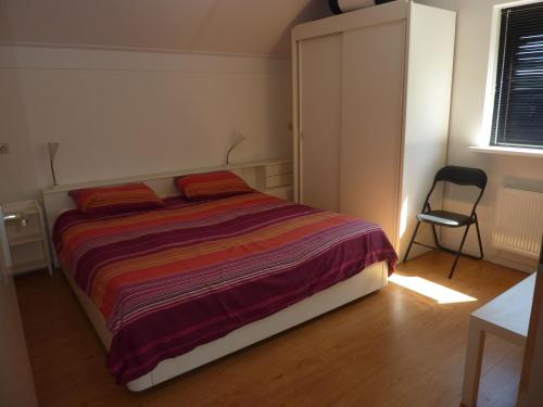 una camera da letto con un letto e una sedia di vakantiehuisgalamadammen met ligplaats boot a Koudum