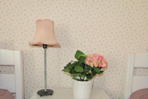 a lamp and a vase of flowers on a table at Koidula Pesa in Haapsalu