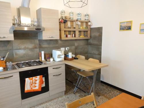 a kitchen with a table and a stove top oven at B&B Al Fronte del Porto in Genoa