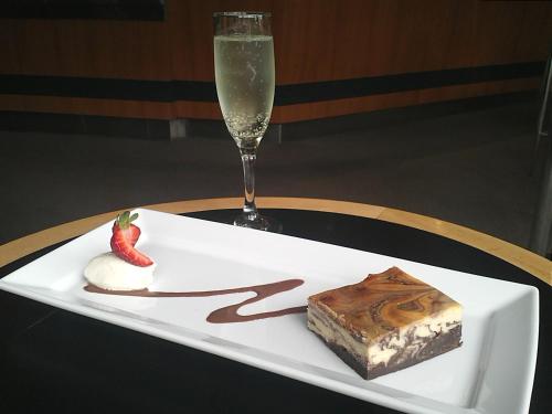 a plate with a piece of cake and a glass of champagne at View Brisbane in Brisbane