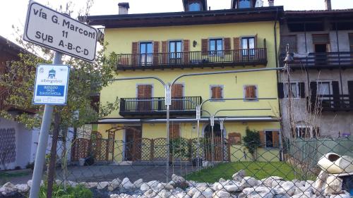a street sign in front of a yellow building at Albergo Casavecchia in Tiarno di Sopra
