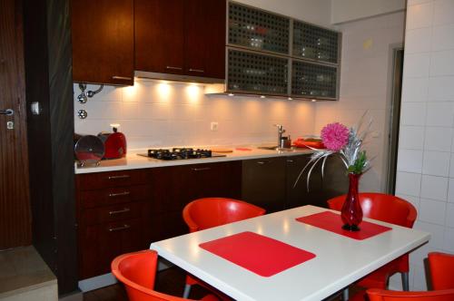 フンシャルにあるvista dos arrifesの赤い椅子と花瓶付きのテーブルが備わるキッチン
