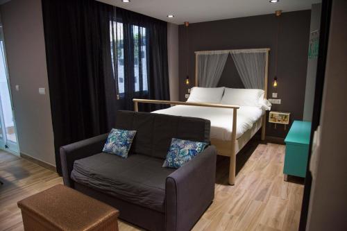 1 dormitorio con 1 cama, 1 sofá y 1 silla en Kasa Kata en Granada