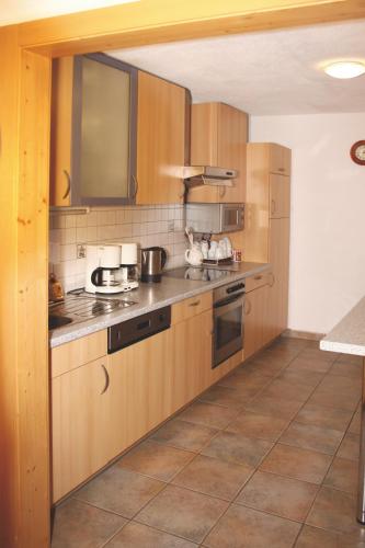 a kitchen with wooden cabinets and a counter top at Gästehaus Schwoagerhof in Fügen
