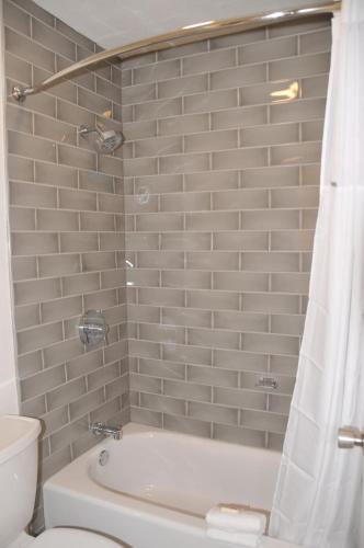 a bathroom with a white tub and a toilet at Howard Johnson by Wyndham Florence in Florence