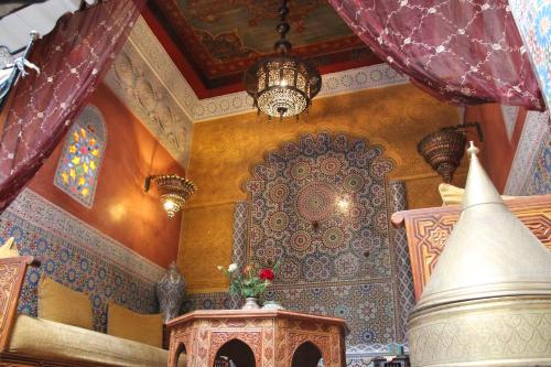 a room with a large ornamental wall and a chandelier at Riad Bibtia in Marrakech