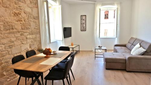 a living room with a table and a couch at City Center Premium Apartment in Poreč