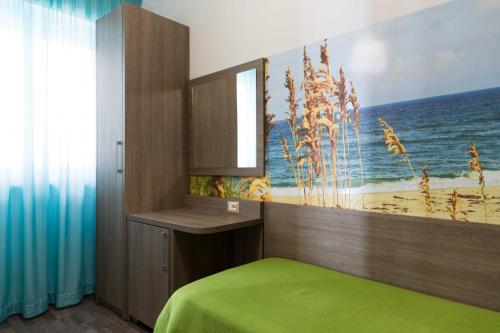a bedroom with a bed and a painting of the ocean at Hotel Miramare in Pineto