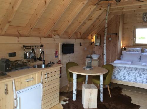 - une cuisine et une chambre dans une petite maison dans l'établissement Shanti Lac Cabanes gîtes insolites et espace bien-être Bordeaux, à Berson