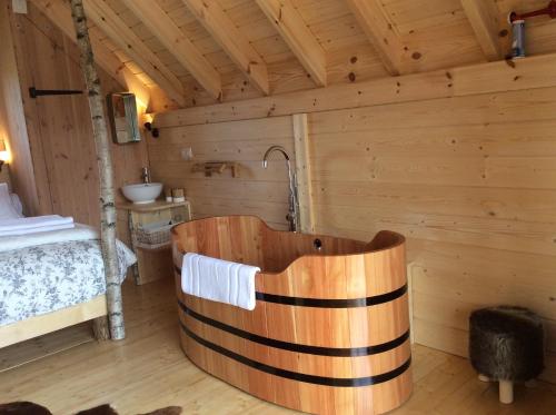 a wooden bathroom with a tub in a room at Shanti Lac Cabanes gîtes insolites et espace bien-être Bordeaux in Berson