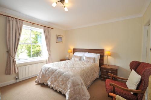 1 dormitorio con cama, ventana y silla en Marton Grange Country House, en Bridlington