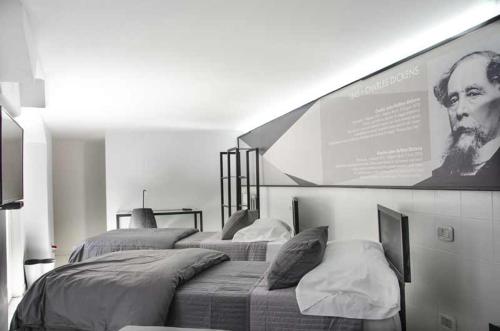 two beds in a room with a large picture on the wall at Muta House in Sorrento