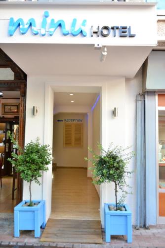 a hotel entrance with two potted plants in front of it at Minu Hotel in Fethiye