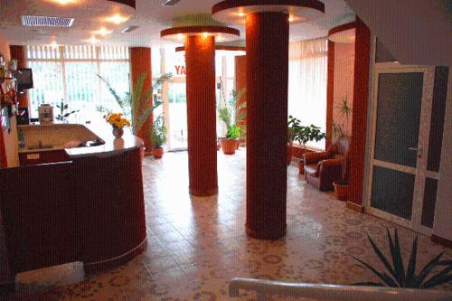 eine Lobby mit orangefarbenen Säulen in einem Gebäude in der Unterkunft Hotel Holiday in Eforie Nord