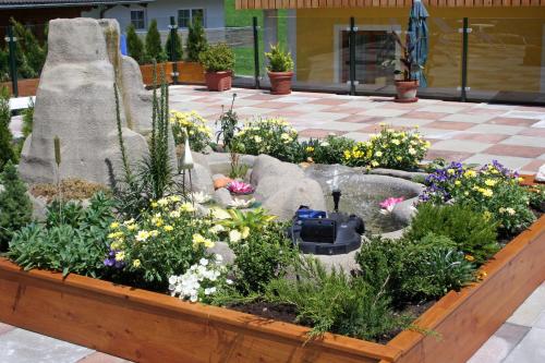 a garden with flowers in a flower bed at Hotel-Pension Egger in Grossarl