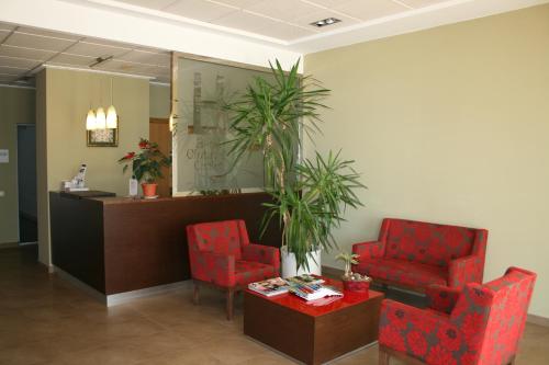 una sala de espera con 2 sillas rojas y un escritorio en Hotel Ciutat de Carlet, en Carlet