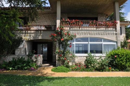 a house with a balcony with red flowers on it at Apartments Vila Toni in Portorož