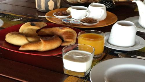 a table with a plate of pastries and glasses of milk at Laguna Blu - Resort Madagascar in Andavadoaka