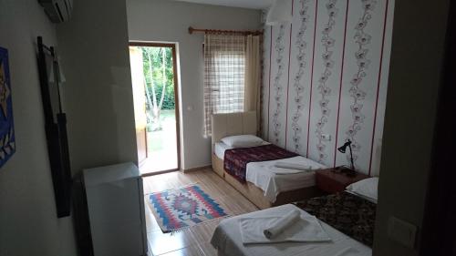 um quarto com 2 camas e uma porta de vidro deslizante em Sirius Hotel em Dalyan