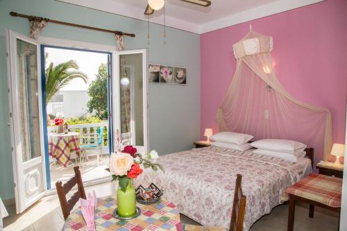 a bedroom with a bed with a pink wall at Filoxenia Studios in Vromolithos