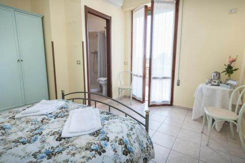 a bedroom with a bed and a table and chairs at Camere Mariella in Bastia Umbra