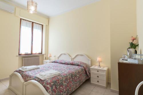a bedroom with a bed and a dresser and a window at Camere Mariella in Bastia Umbra
